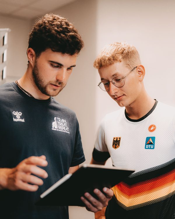 Nils Färber bespricht mit einer Athletin Befunde auf einem Tablet